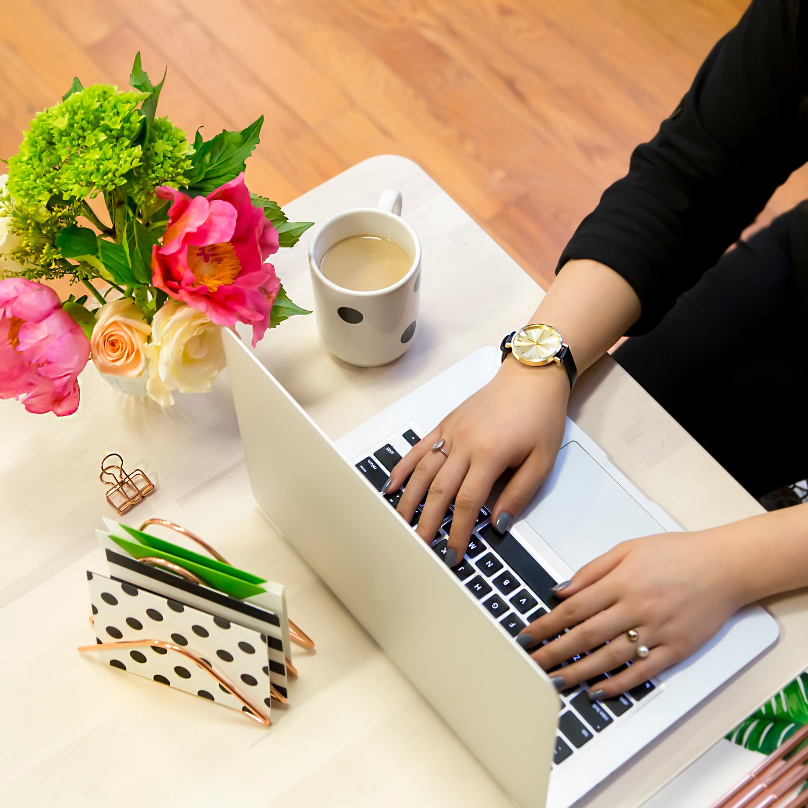 Three women smiling and working together on a laptop, symbolizing collaboration and teamwork.